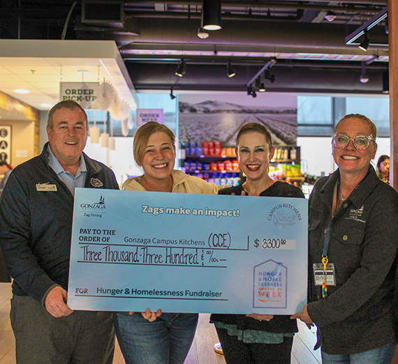 Una mujer está de pie con los brazos cruzados junto a una ventana.